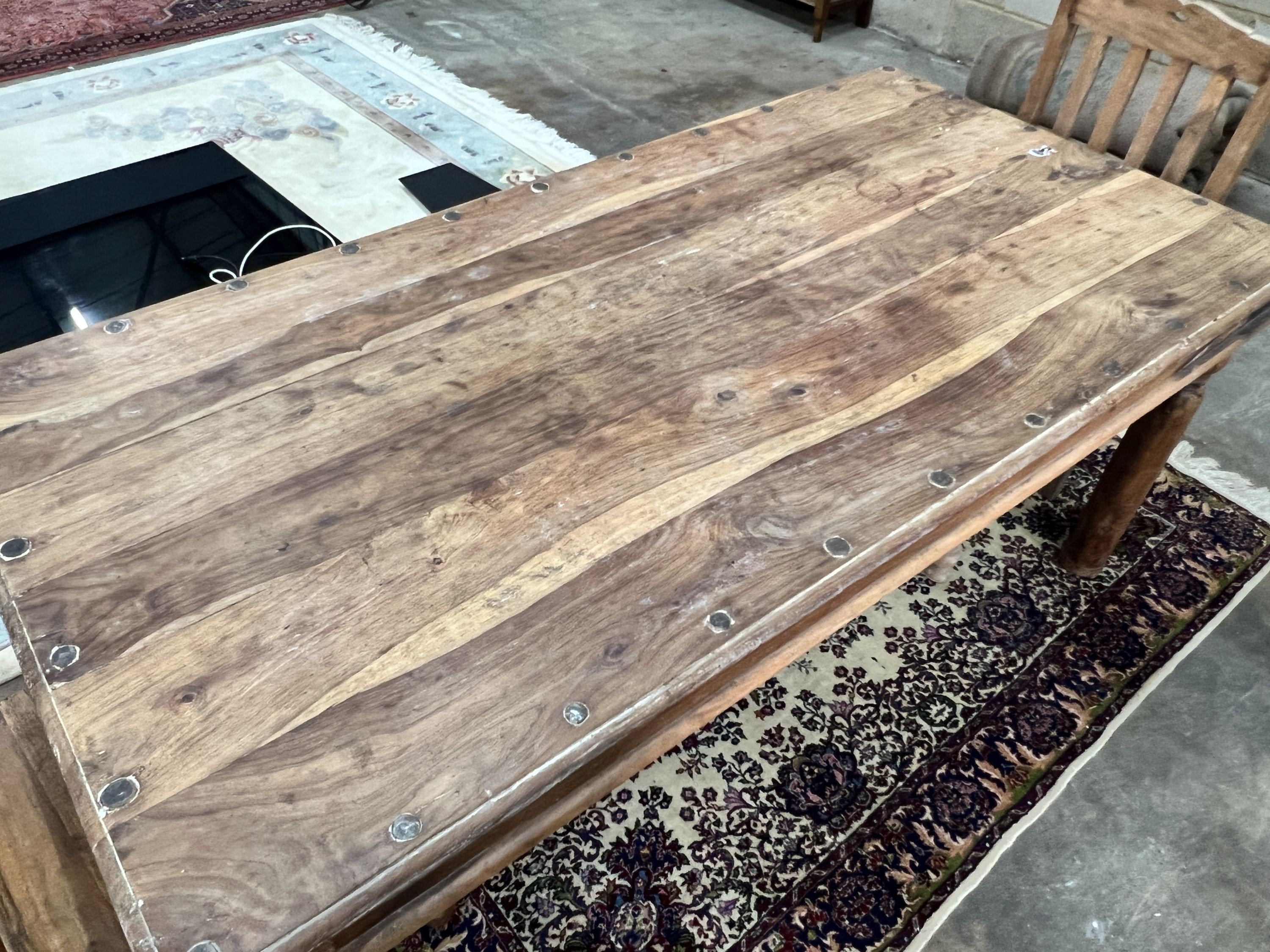 An Indonesian rectangular studded hardwood dining table, length 180cm, depth 90cm, height 76cm and two chairs